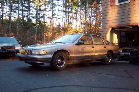 2001 Ford Crown Victoria - Two sedans, a 1995 Chevrolet Caprice and a Ford Crown Victoria, are parked in a driveway.