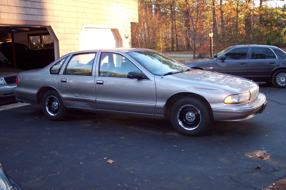 Silver 1990s Chevrolet Caprice sedan parked in driveway, another sedan behind it