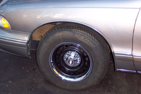 2001 Ford Crown Victoria - The front wheel and fender of a Chevrolet Caprice are shown in this close-up photo.