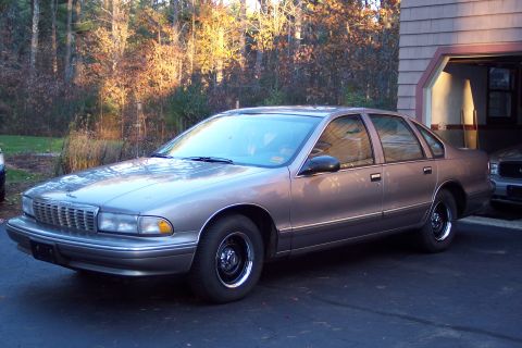 2001 Ford Crown Victoria - This sedan has a distinctive grille and body style typical of mid-1990s Chevrolet Caprice models.