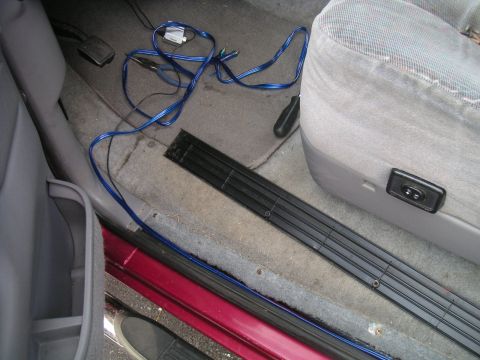 1994 Ford Bronco - Wiring is laid out on the floor of a vehicle's interior, near the driver's seat and door.