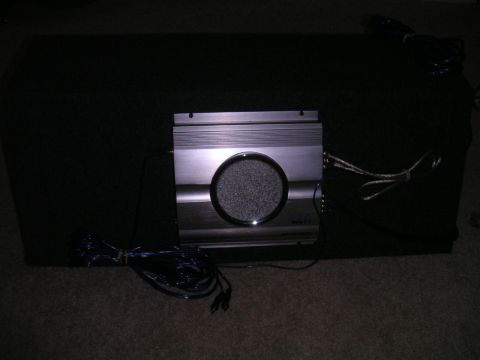 1994 Ford Bronco - A car amplifier is attached to a subwoofer enclosure, with audio cables visible.