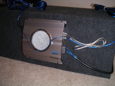 1994 Ford Bronco - A car amplifier is connected to a subwoofer box, with visible wiring and a label indicating 600 watts.