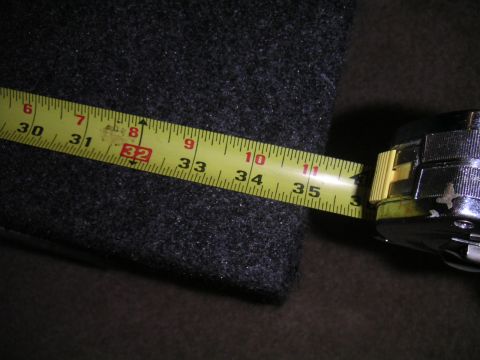 1994 Ford Bronco - A tape measure is used to measure a carpeted box, with markings visible up to 35 inches.