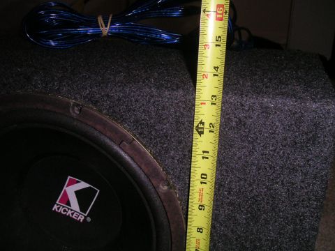 1994 Ford Bronco - Close-up of a Kicker subwoofer, measuring tape indicates its size.