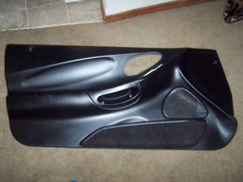 Black car door panel with speaker grille and fabric insert