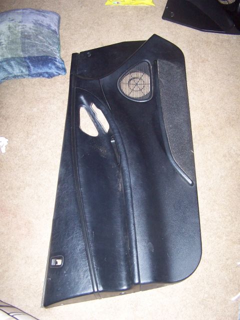 1994 Ford Probe - A detached car door panel is shown lying on a carpeted floor next to a pillow.