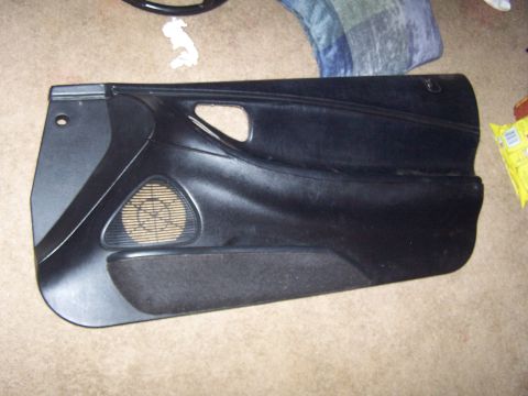 1994 Ford Probe - A black car door panel is shown from an interior perspective, resting on a carpeted floor.