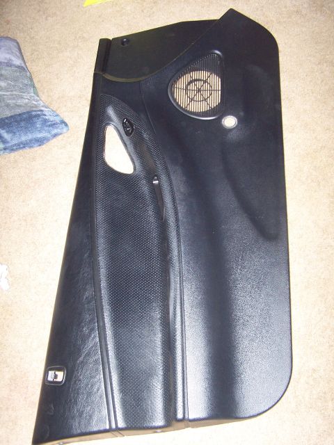 1994 Ford Probe - Black car door panel with textured insert and speaker grille.