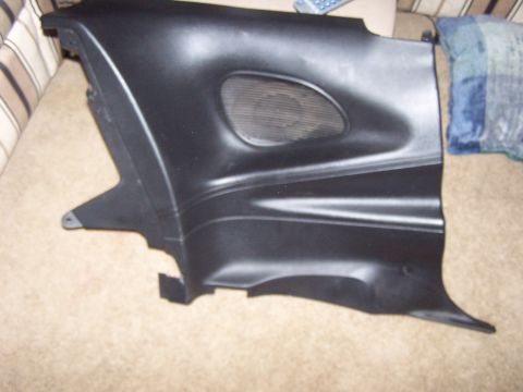 1994 Ford Probe - A black plastic interior trim piece with an oval speaker grille is shown against a carpeted background.