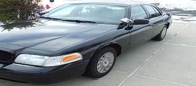 2003 Ford Crown Victoria - The 2003 Ford Crown Victoria is shown from a three-quarter front angle, highlighting its black exterior and clean condition.