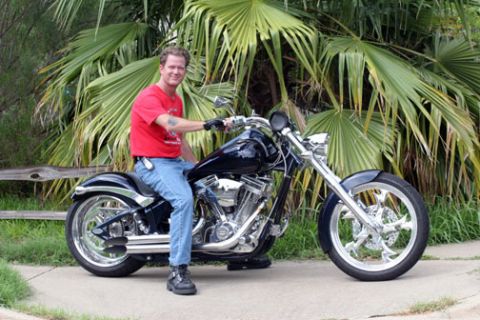 2005 Big Dog Mastiff - Man poses on a custom motorcycle, with "SUPERMOTORS" logo visible.