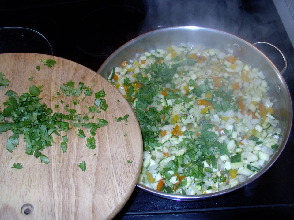 Add in the Cilantro (Corriander) too. I keep the remainder, you see on the board, to add into the sauce just before serving.