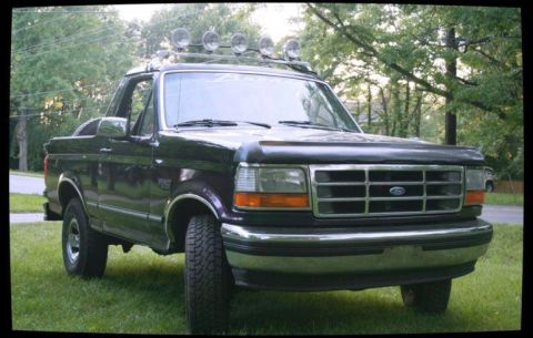 1993 Ford Bronco - This Ford Bronco has a roof rack with four lights and a bug deflector on the hood.