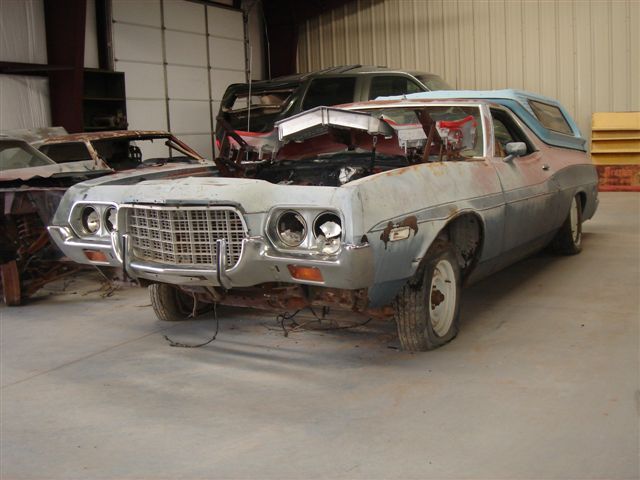 Light blue 1970s Ranchero parts car with hood removed inside a shop building