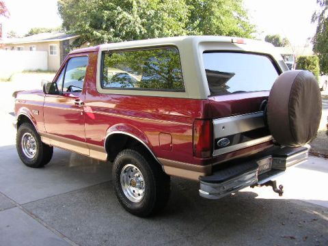 1994 Ford Bronco - This 1994 Ford Bronco is shown from the rear three-quarter angle, its iconic two-tone paint and external spare tire.