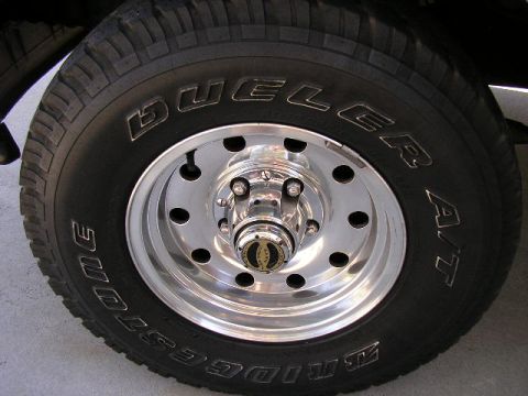 1994 Ford Bronco - This image shows a close-up of a Bridgestone Dueler A/T tire mounted on a chrome wheel.