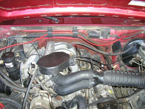 1994 Ford Bronco - The engine bay of a 1994 Ford Bronco shows its internal components and wiring.