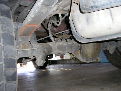 1994 Ford Bronco - Close-up view of the undercarriage, focusing on the rear suspension and axle assembly.