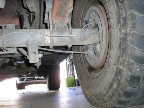 1994 Ford Bronco - Close-up view of a vehicle's rear axle and suspension components, with another vehicle partially visible below.