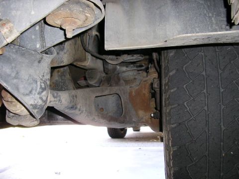 1994 Ford Bronco - Underside view of vehicle suspension system, showing rust and wear on components.