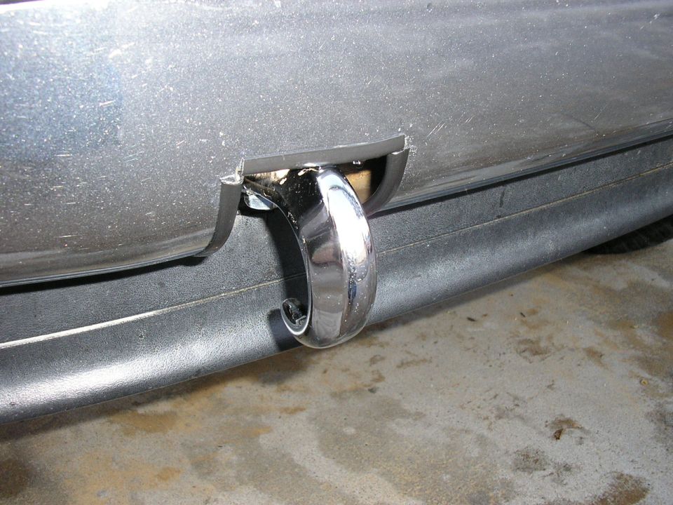 Close-up of a chrome tow hook attached to the underside of a vehicle's bumper