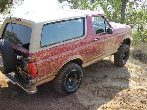 1994 Ford Bronco - This 1994 Ford Bronco is covered in mud after driving on a dirt path.