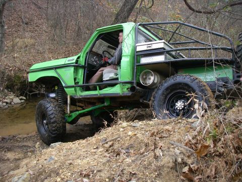 1978 Ford Bronco - A heavily modified 1978 Ford Bronco navigates a challenging off-road course with a driver inside.