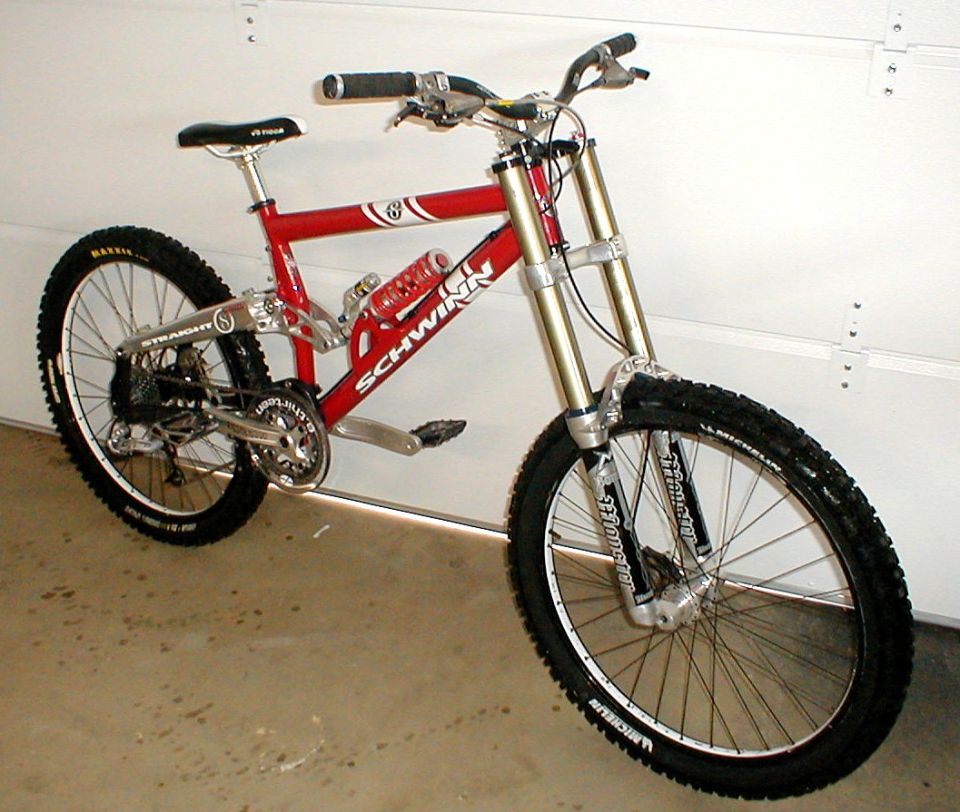 Red Schwinn mountain bike with dual suspension and thick tires, angled from the front