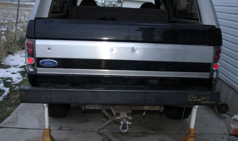 1994 Ford Bronco - The rear of a Ford Bronco is shown, a custom steel bumper and a Ford logo on the tailgate.