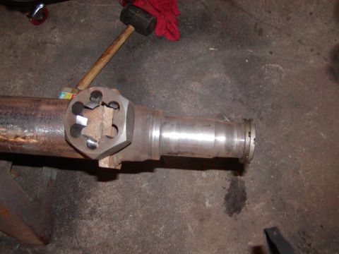 1991 Ford Bronco - A differential axle housing is shown with a tool attached, and a sledgehammer is visible in the background.