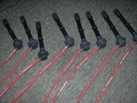 1997 Ford Crown Victoria - Set of red Ford Racing spark plug wires with black boots, laid out on a carpeted surface.
