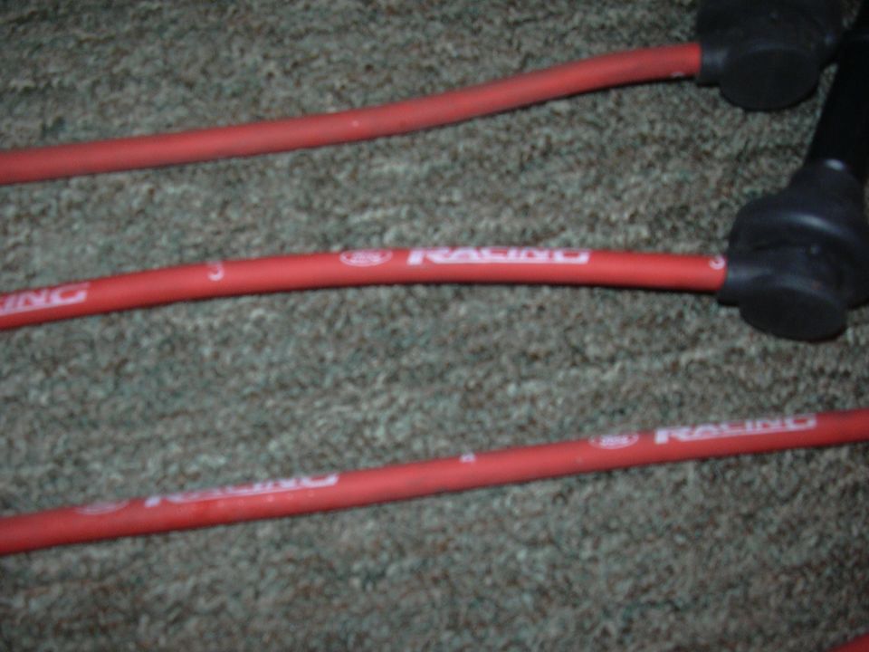 Red spark plug wires with white text that reads 'RACING'