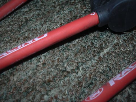1997 Ford Crown Victoria - Red spark plug wires with white lettering are shown on a textured surface.