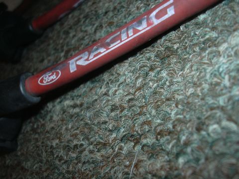 1997 Ford Crown Victoria - A close-up view of a red Ford Racing spark plug wire against a carpeted background.