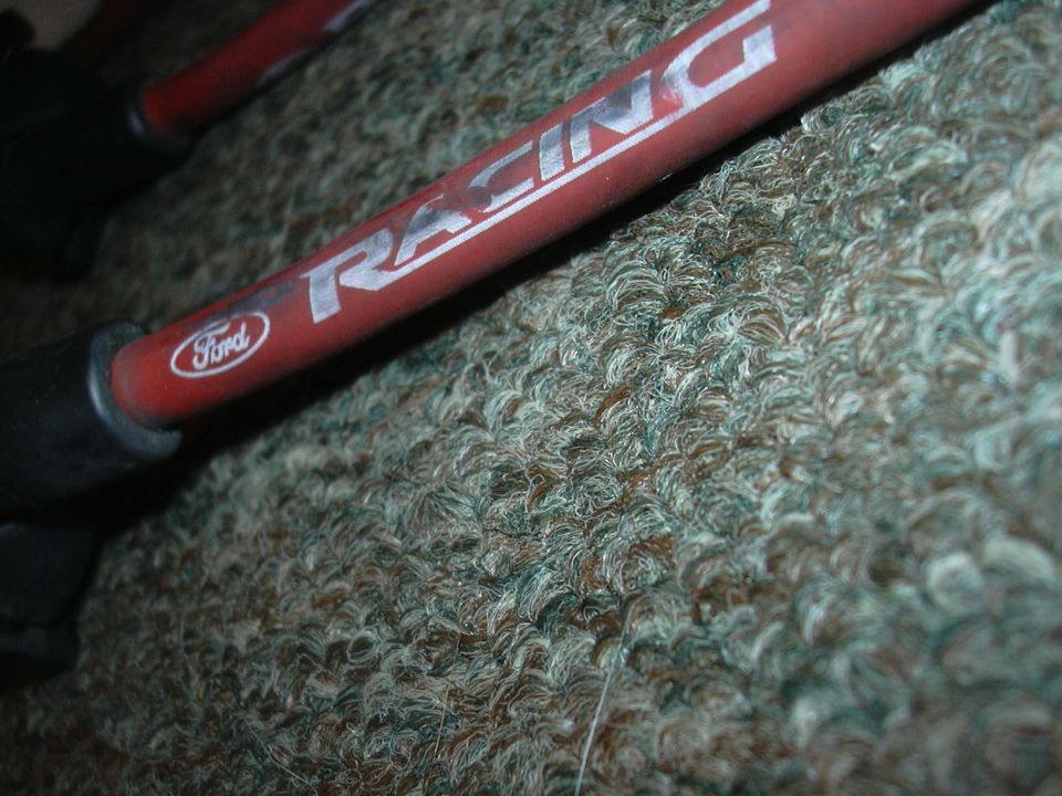 Red Ford Racing spark plug wire with silver lettering on a textured surface