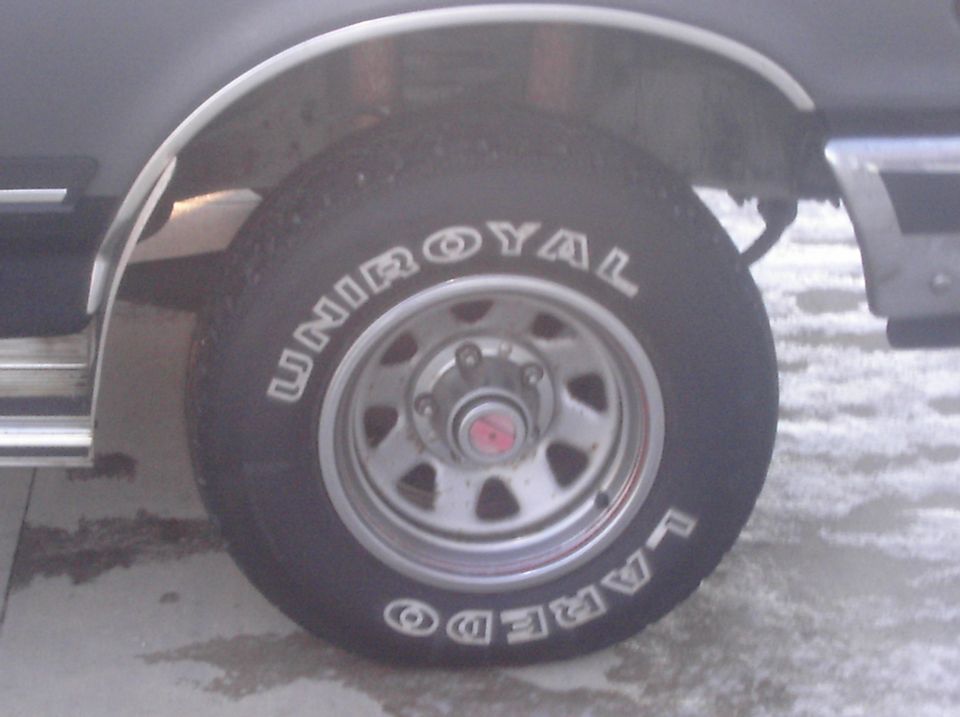 Close-up of a Uniroyal Laredo tire on a vehicle wheel with a chrome fender flare