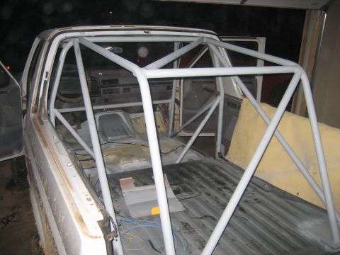 1996 Ford Bronco - This white pickup truck's interior is fitted with a custom roll cage and yellow padding, suggesting a modification for racing or off-road u…