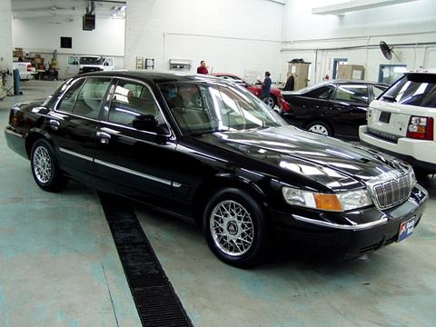 2000 Mercury Grand Marquis - A black 2000 Mercury Grand Marquis is parked in a garage, with other vehicles visible in the background.