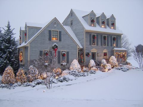 1996 Mercury Grand Marquis - A suburban home is adorned with festive Christmas lights and wreaths, blanketed in fresh snow.