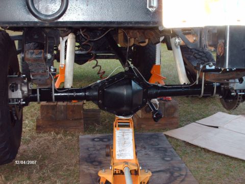 1982 Ford F-100 - Rear view of a freshly painted black rear axle with a large bolted differential cover, disc brakes and routed brake hoses, held up on an or…