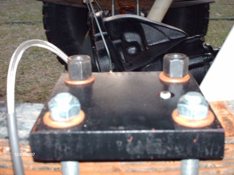 1982 Ford F-100 - A close-up view of a vehicle's differential housing and a custom mounting plate, with visible bolts and washers.