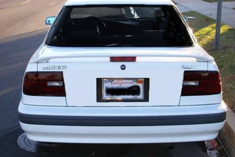 1991 Mazda MX-6 - Rear view of a white 1991 Mazda MX-6, showing the taillights and spoiler.