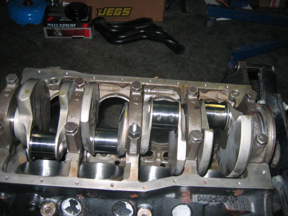 engine block with crankshaft and connecting rods installed, JEGS box and exhaust manifold in background