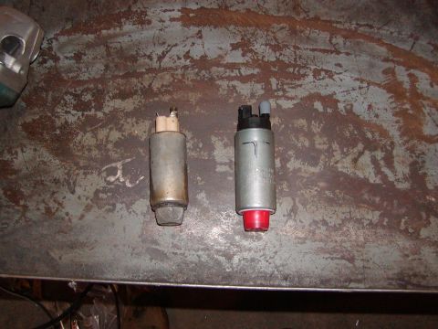 1991 Ford Bronco - Two fuel pumps are shown side-by-side on a worn metal surface, one appearing older than the other.
