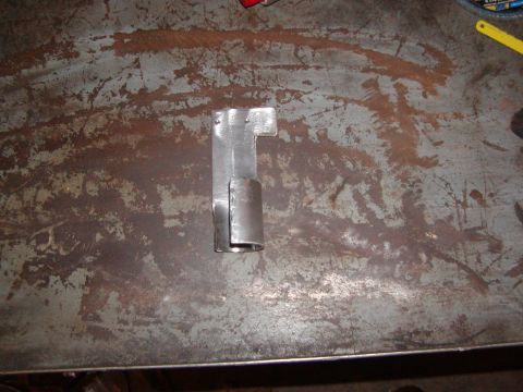 1991 Ford Bronco - A custom metal bracket is shown on a worn workbench surface.