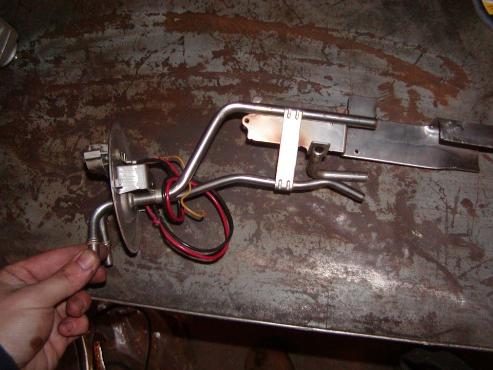 Fuel pump assembly with metal lines and electrical connectors on a workbench