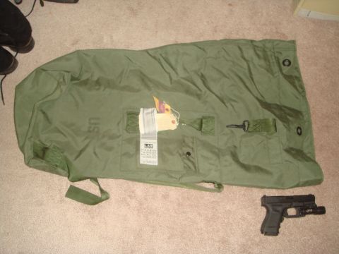 1992 Ford Bronco - A green duffel bag and a handgun are placed on a carpeted floor.