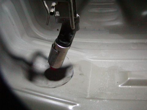 1991 Ford Bronco - Close-up of a fuel pump assembly being installed or removed from a vehicle's fuel tank.