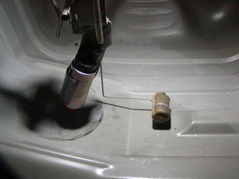 1991 Ford Bronco - Close-up of a fuel pump and sender assembly within a vehicle's fuel tank.